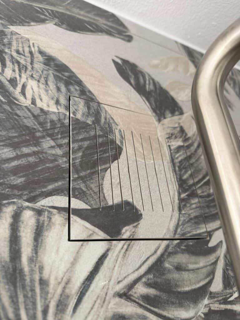 Detalje af grafisk tapet med organisk mønster på badeværelse.